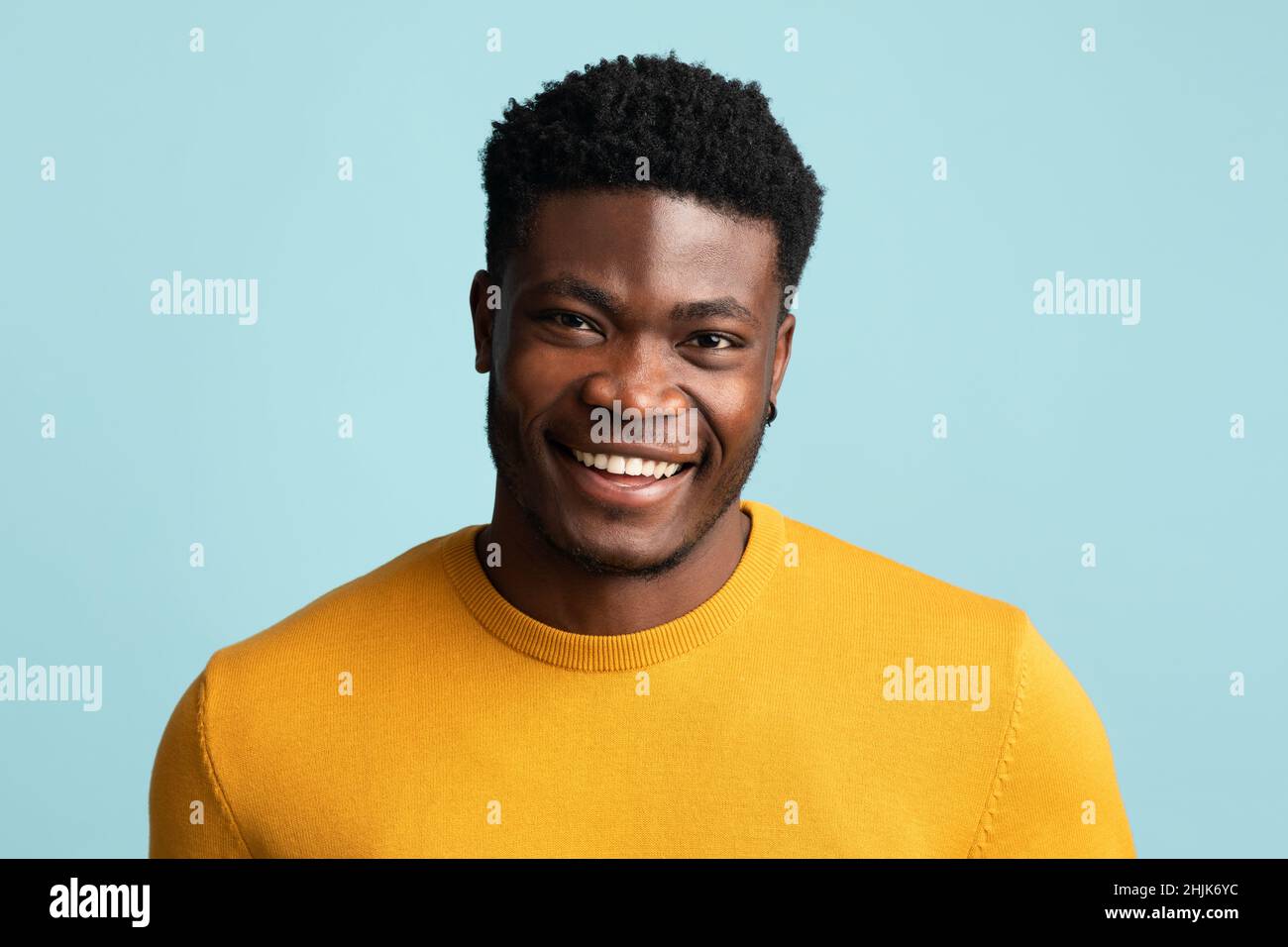 Porträt eines schönen afroamerikanischen Mannes, der auf Blau posiert Stockfoto