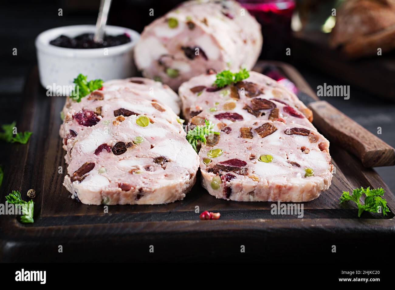 Köstliche Fleischterrine mit Hühnchen in Scheiben, grünen Erbsen und getrockneten Früchten. Hackbraten. Stockfoto