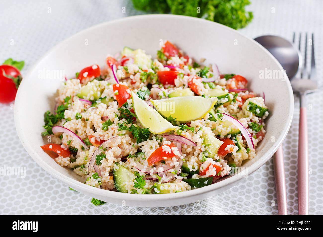 Salat aus Tabbouleh. Traditionelles mittelöstliches oder arabisches Gericht. Levantiner vegetarischer Salat mit Petersilie, Gurke, Couscous, Tomaten. Stockfoto