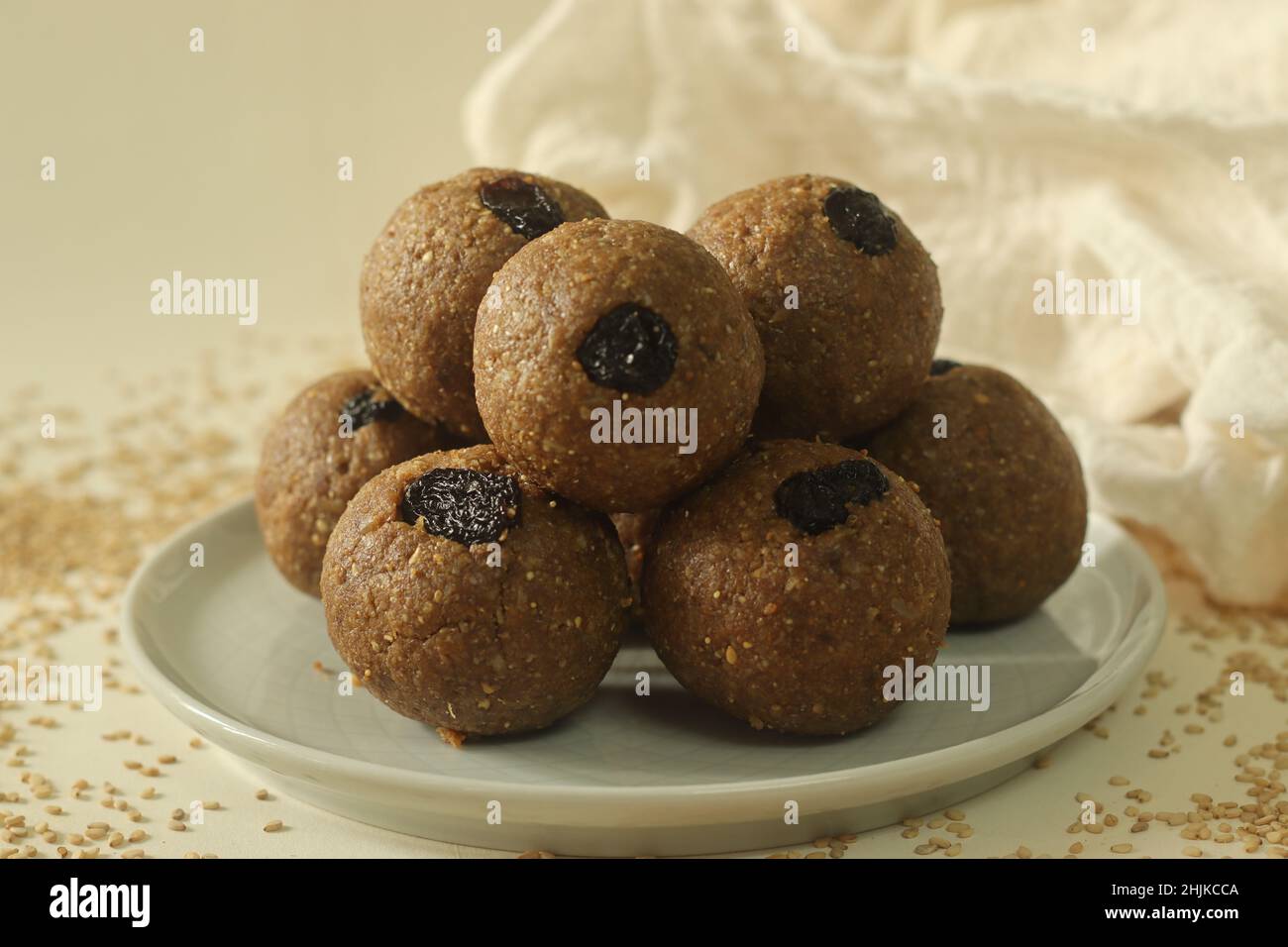 Weiß bis zum Laddu. Ein gesundes, köstliches und nussiges indisches Süßgericht, zubereitet mit weißen Sesamkörnern, Jaggery, frisch geriebener Kokosnuss und Rosinen. Aufnahme Stockfoto