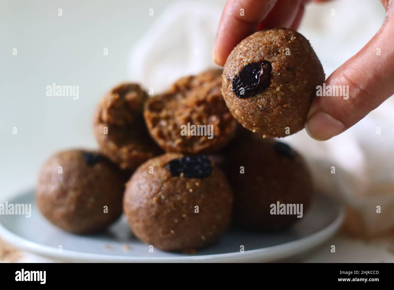Weiß bis zum Laddu. Ein gesundes, köstliches und nussiges indisches Süßgericht, zubereitet mit weißen Sesamkörnern, Jaggery, frisch geriebener Kokosnuss und Rosinen. Aufnahme Stockfoto