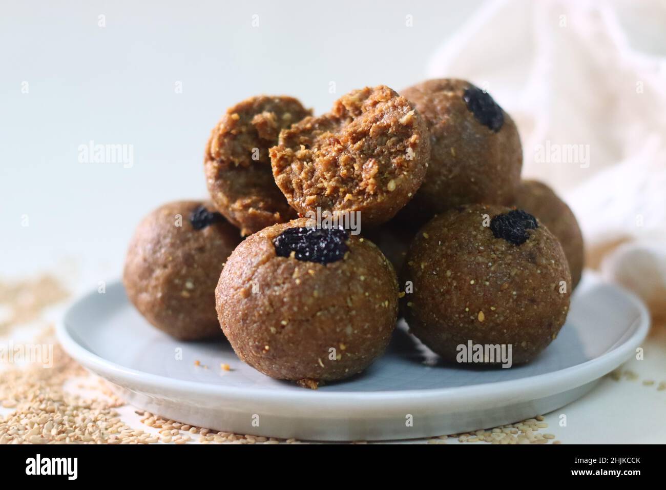 Weiß bis zum Laddu. Ein gesundes, köstliches und nussiges indisches Süßgericht, zubereitet mit weißen Sesamkörnern, Jaggery, frisch geriebener Kokosnuss und Rosinen. Aufnahme Stockfoto