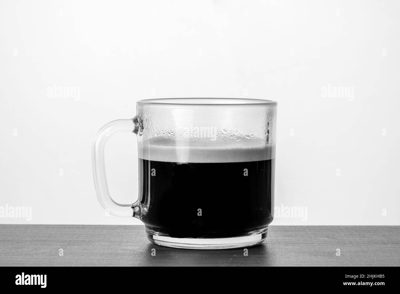 Eine Tasse Kaffee auf einem schwarz-weißen Tisch Stockfoto