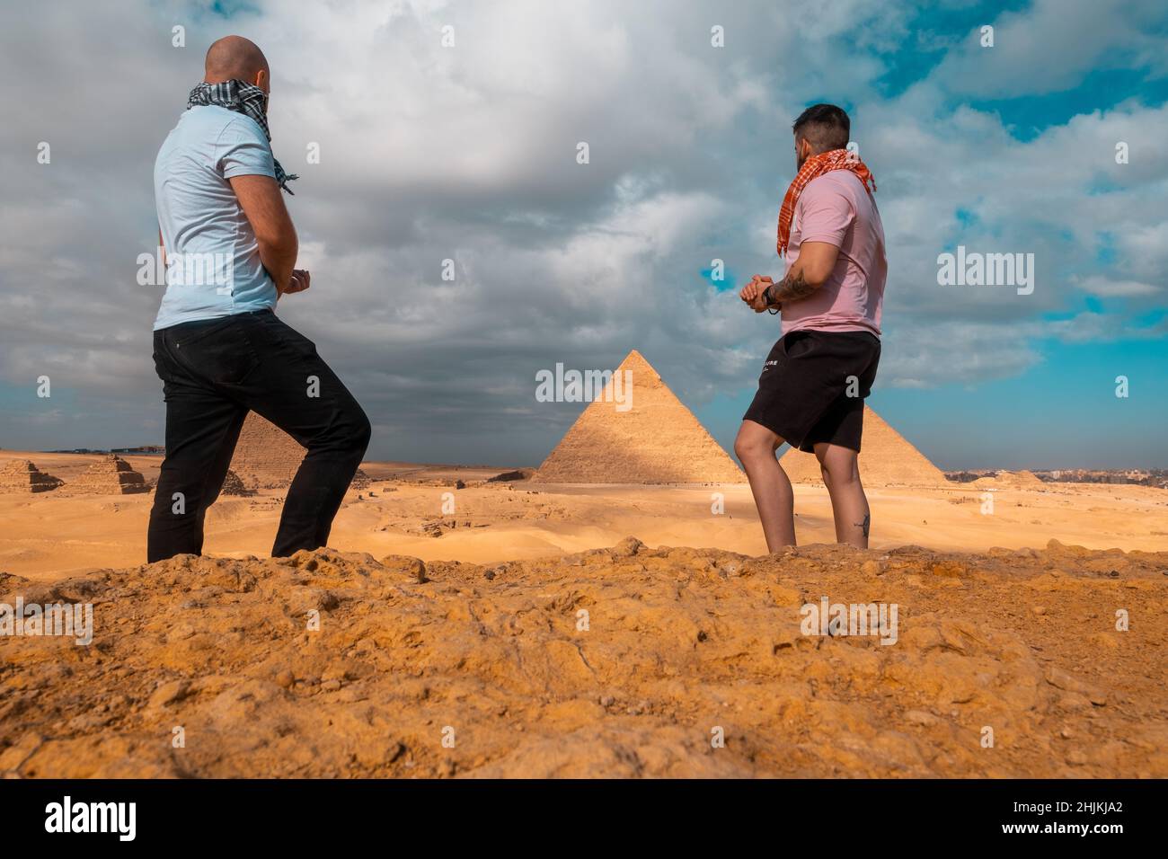Zwei Männer Reisende posieren vor den großen Pyramiden von gizeh in kairo ägypten. Reisen ägypten im Winter, kalten Winter bedeckt Tag. Stockfoto