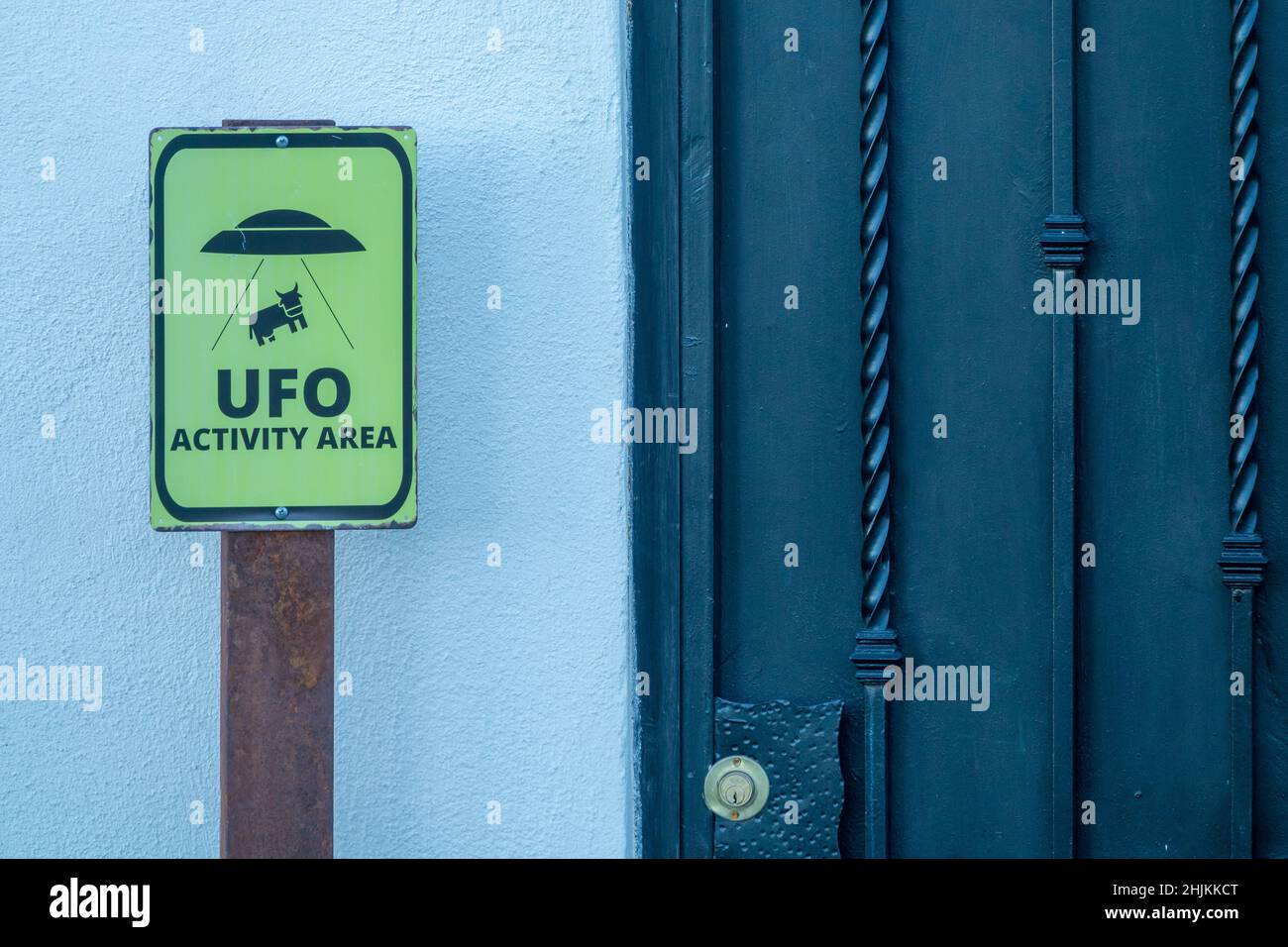 Neugieriges Warnschild „ufo-Aktivitätsbereich“ neben der weißen Außenwand eines Hauses Stockfoto