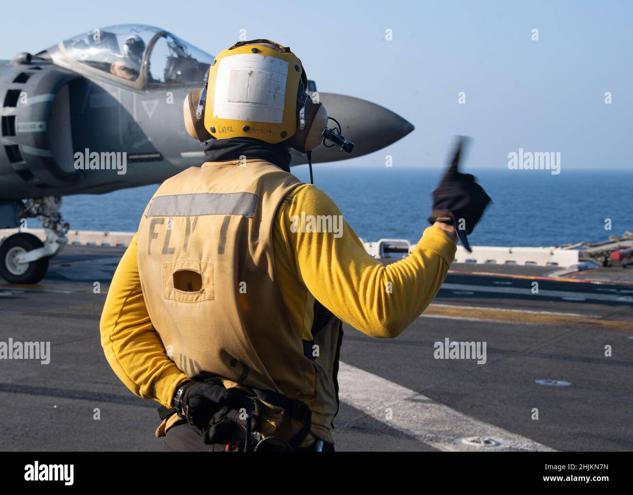 INDISCHER OZEAN (Jan 4, 2022) die Mate 3rd-Klasse von Aviation Boatswain, Thomas McLaughlin, aus Andover, Minnesota, sendet Signale an einen AV-8B Harrier, der an die Marine Attack Squadron 214, 11th Marine Expeditionary Unit (MEU) auf dem Flugdeck des amphibischen Angriffsschiffs USS Essex (LHD 2), Januar 4, angeschlossen ist. Essex, Flaggschiff der Amphibious Ready Group (ARG) von Essex, ist zusammen mit den 11th MEU im Einsatzgebiet der US-Flotte für 7th tätig, um die Interoperabilität mit Allianzen und Partnern zu verbessern und als einsatzbereite Einsatztruppe für die Sicherheit im Seeverkehr und eine freie und offene Region im Indo-Pazifik-Raum zu dienen. Stockfoto