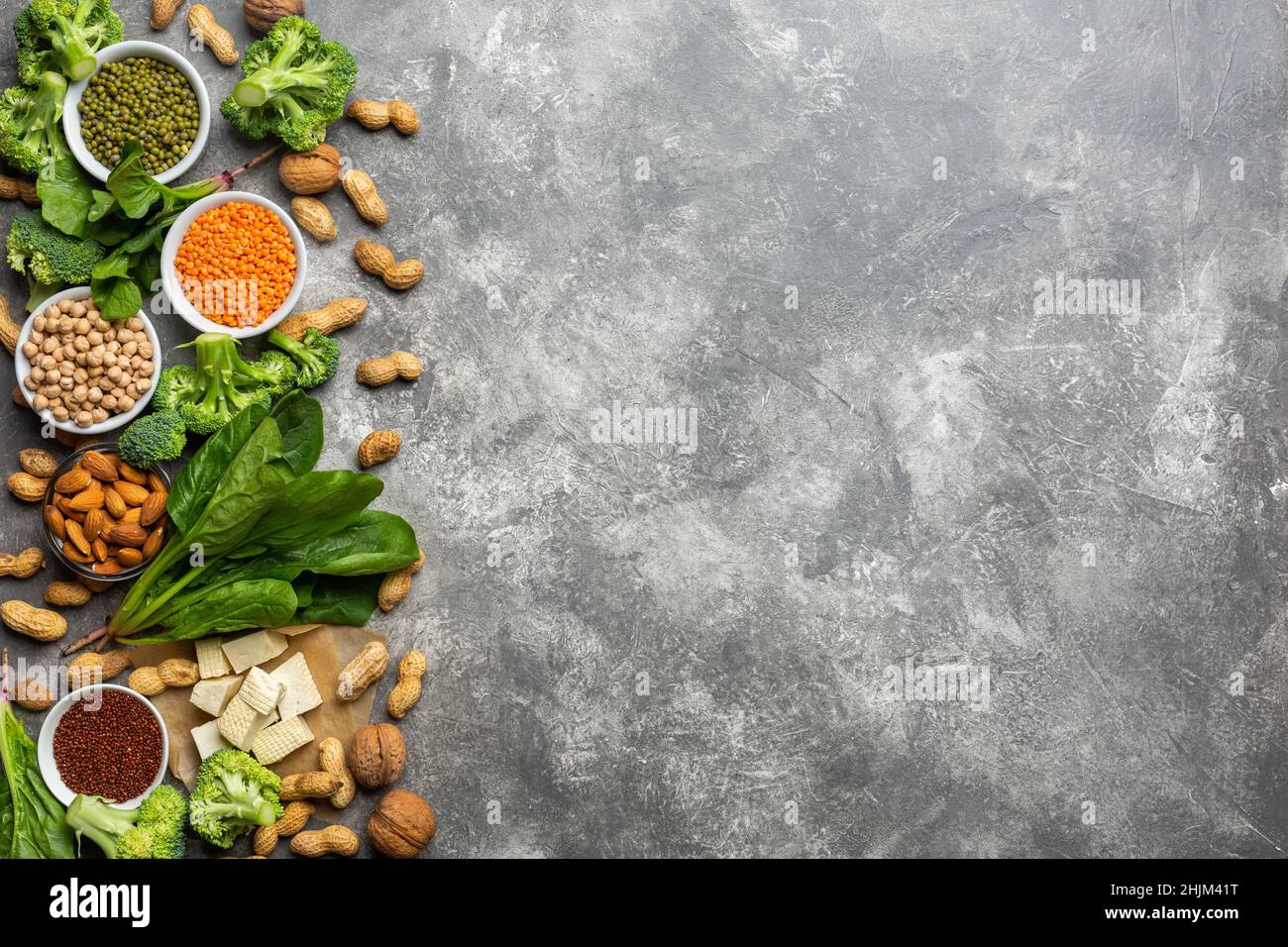 Protein für Vegetarier: Tofu, Gemüse, Nüsse, Samen und Hülsenfrüchte Draufsicht auf einem konkreten Hintergrund. Konzept: Gesunde, saubere Lebensmittel. Stockfoto