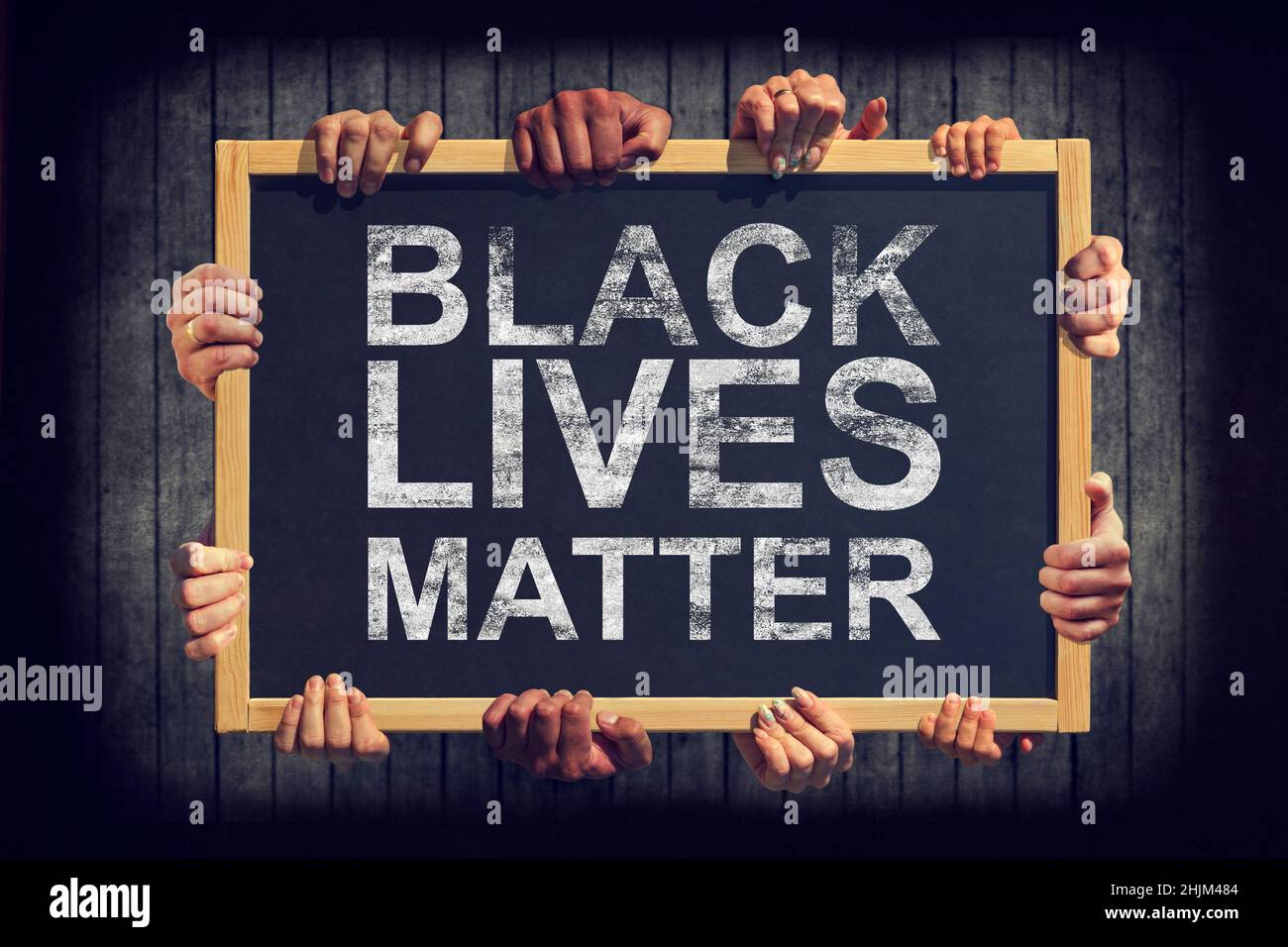 Eine Menge Hand halten ein Banner mit Text SCHWARZE LEBEN MATERIE auf dunklem Hintergrund. Verschiedene Menschen äußern eine gemeinsame Meinung Black Lives Matter. Stockfoto