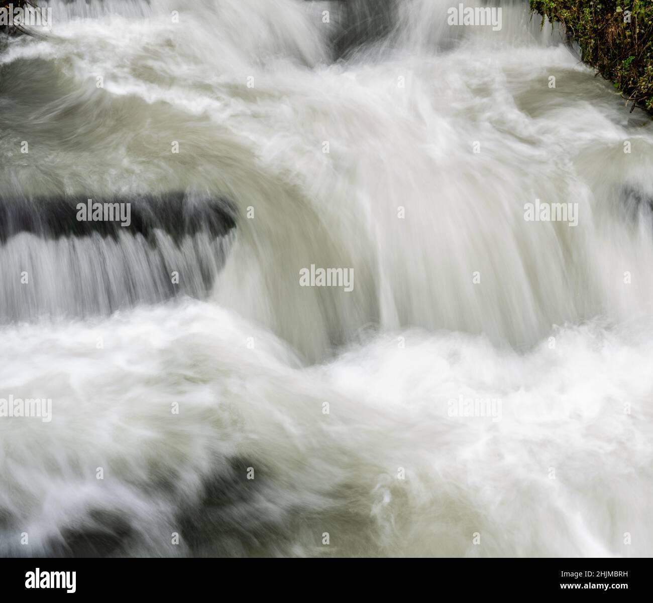 Langzeitbelichtung von Weißwasser, das über einen kleinen Wasserfall im Stadtzentrum von Salisbury UK führt Stockfoto