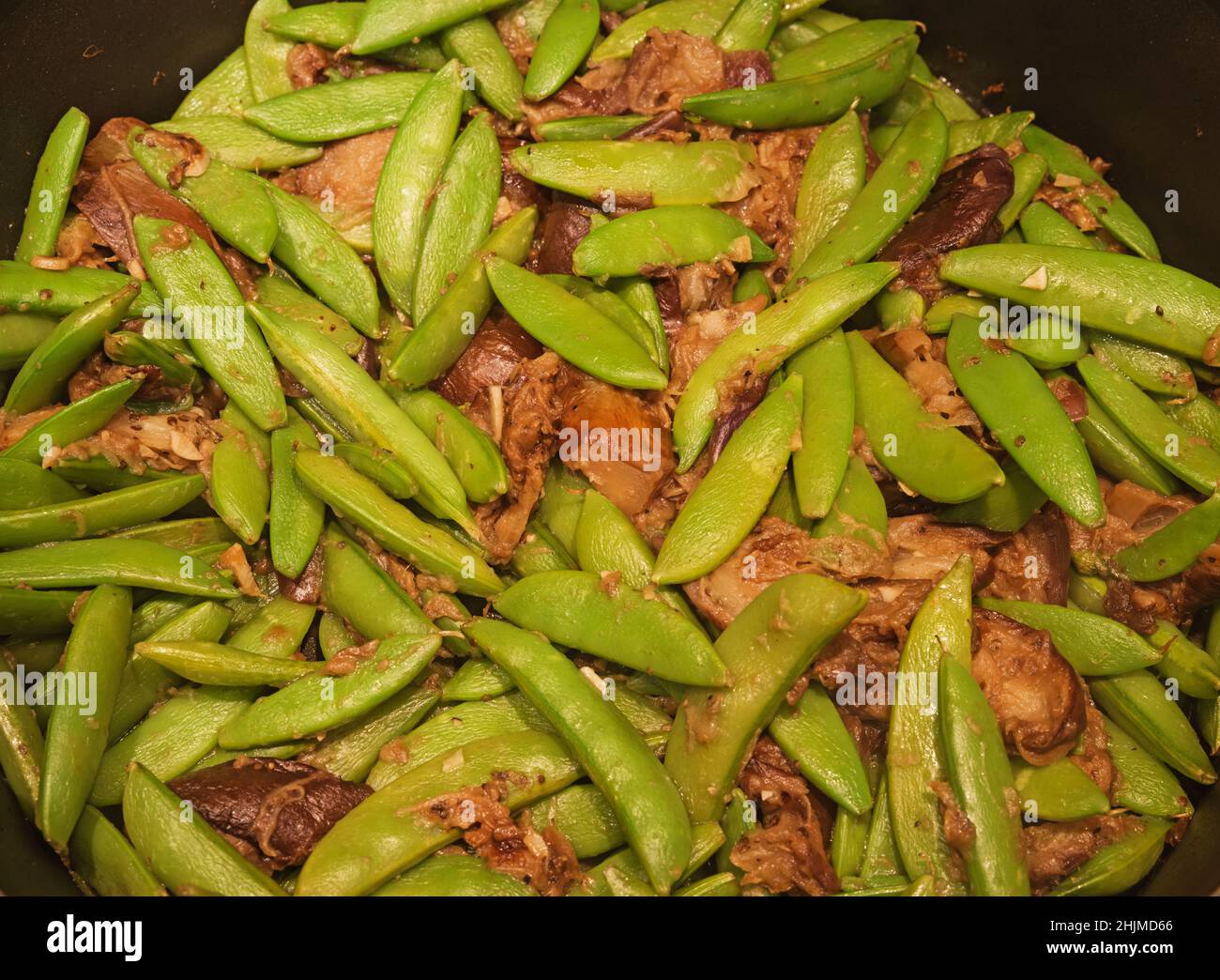 Schnappen Sie Erbsen und Auberginen in einer Pfanne gekocht Stockfoto