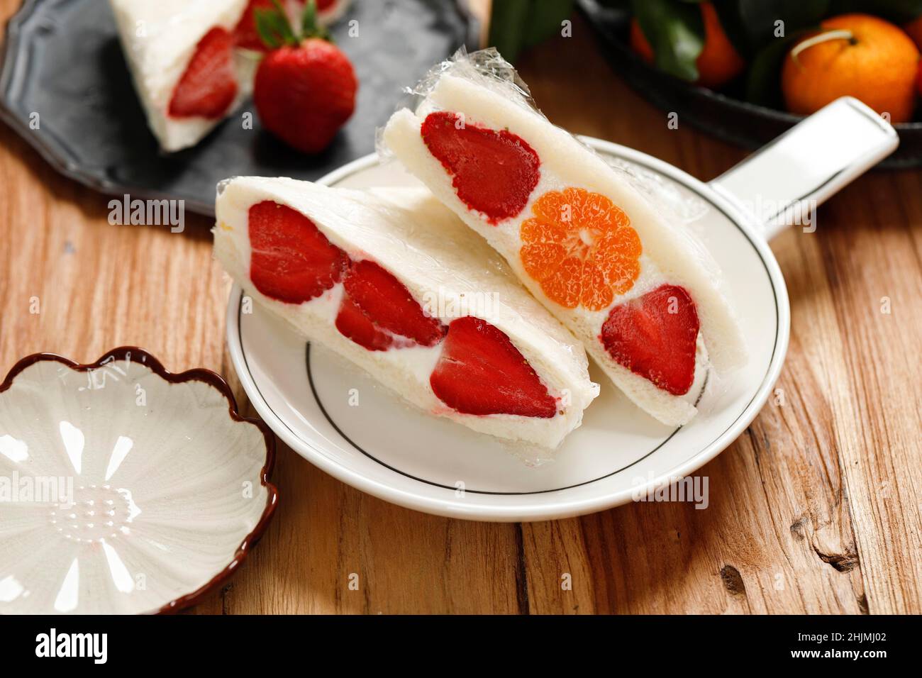 Japanisches Erdbeer- und Orangenfrucht-Sandwich oder Obstsando auf Holztisch Stockfoto