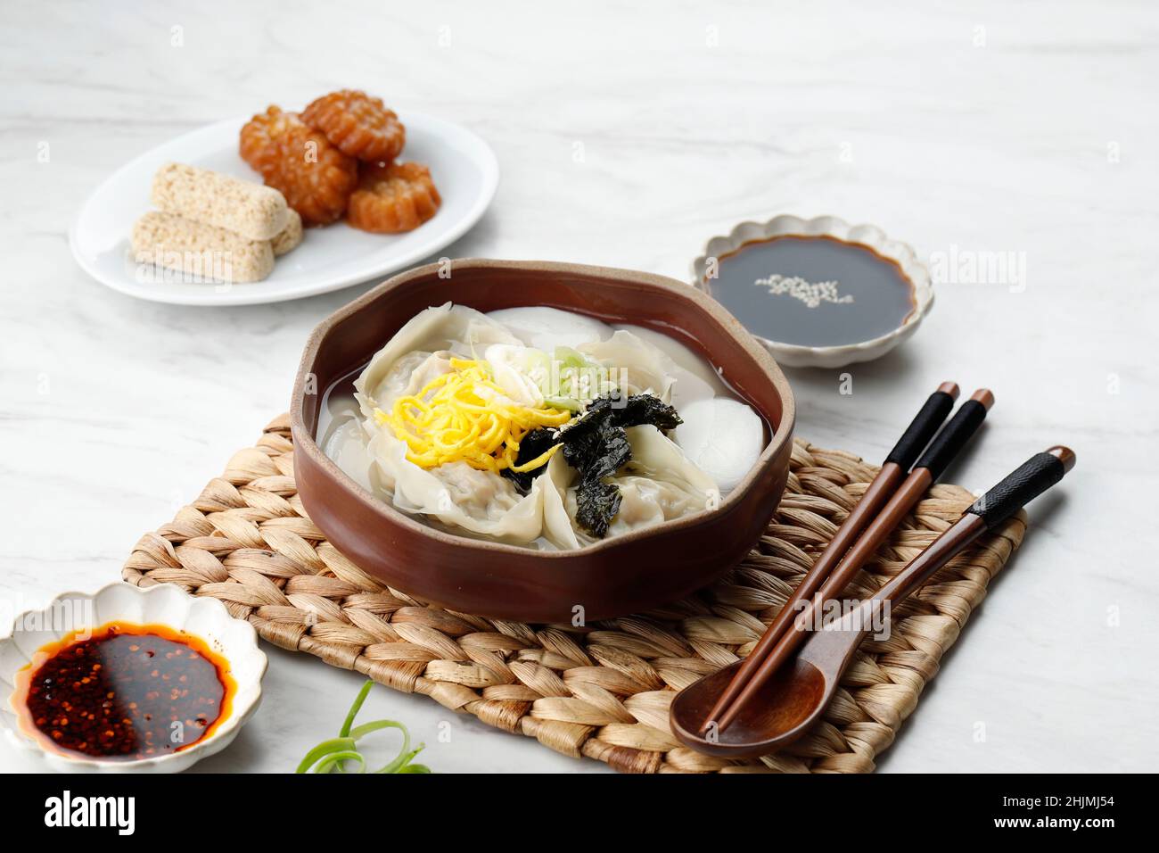 Manduguk koreanische Knödelsuppe, Mandu und klare Brühe mit Nori, Ei und Frühlingszwiebeln. Traditionelle koreanische Suppe für Seollal Stockfoto