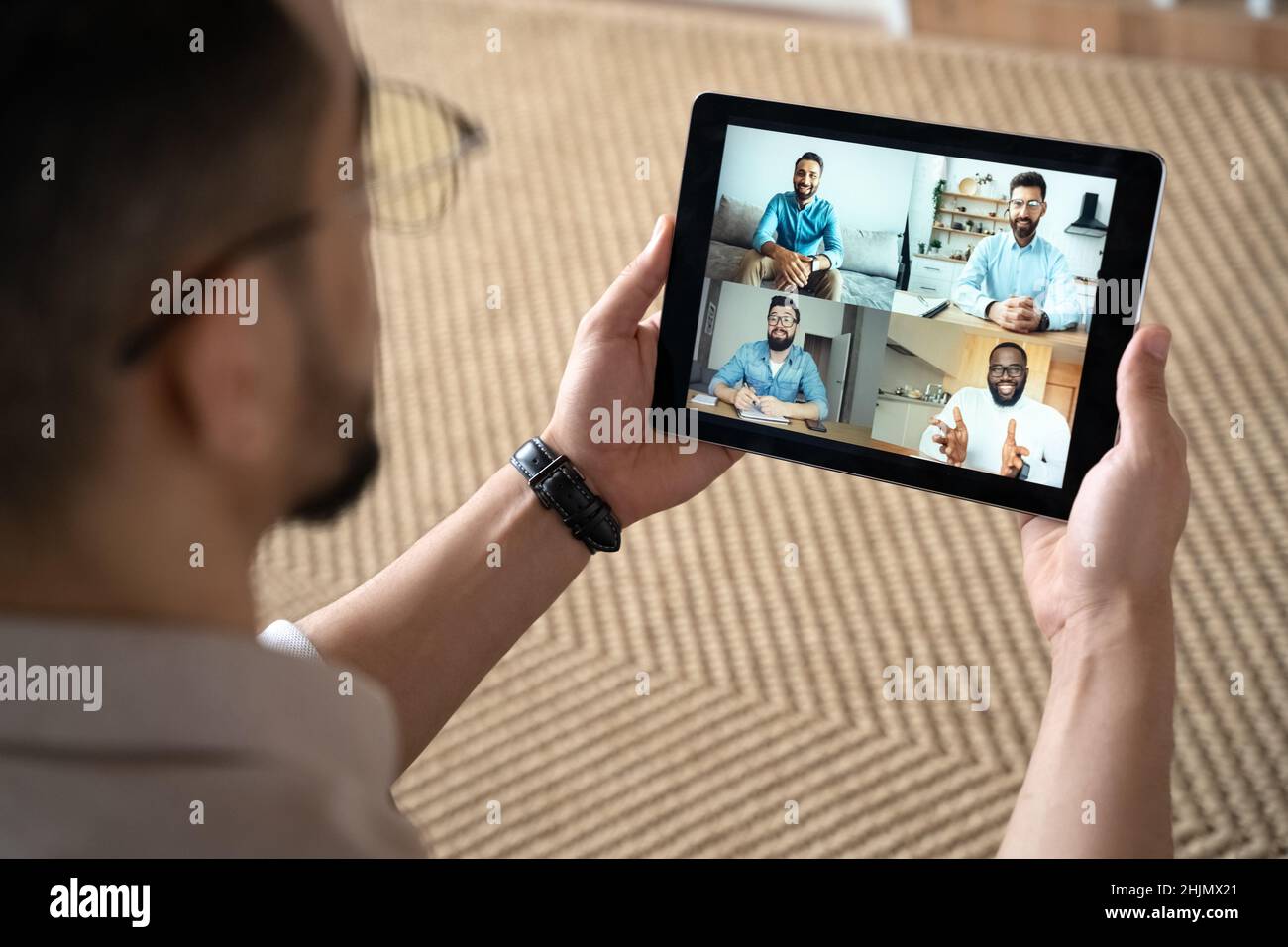 Mann zu Hause mit Online-Meeting virtuelle Konferenz auf digitalem Tablet Stockfoto