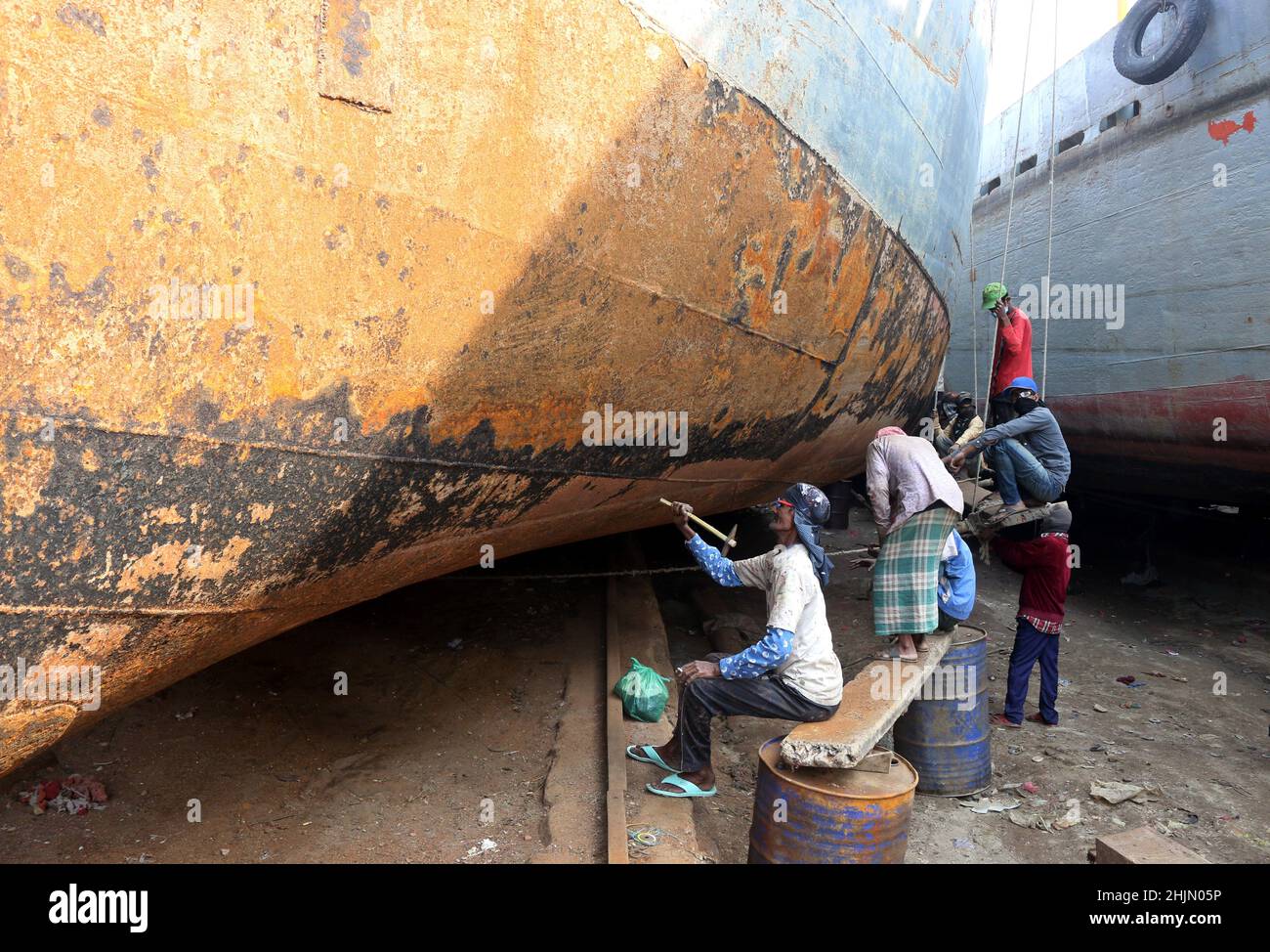 JANUAR 30,01,2022,DHAKA,BANGLADESH- Hafenarbeiter rund um die Schiffe entlang des Flusses Buriganga. Die Schiffbauindustrie in Bangl Stockfoto