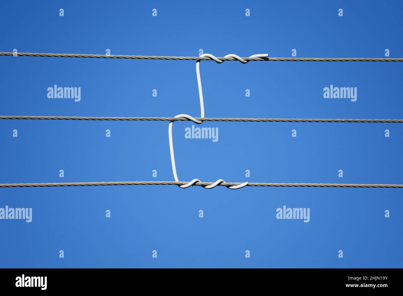 Freileitung mit benutzerdefiniertem Kabelabstandhalter. Nahaufnahme. Blauer Himmel Hintergrund Stockfoto