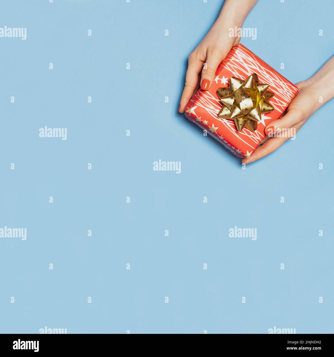 Schöne rote Geschenkbox mit Schleife in den Frauenhänden, Draufsicht, Platz für Text kopieren. Stockfoto