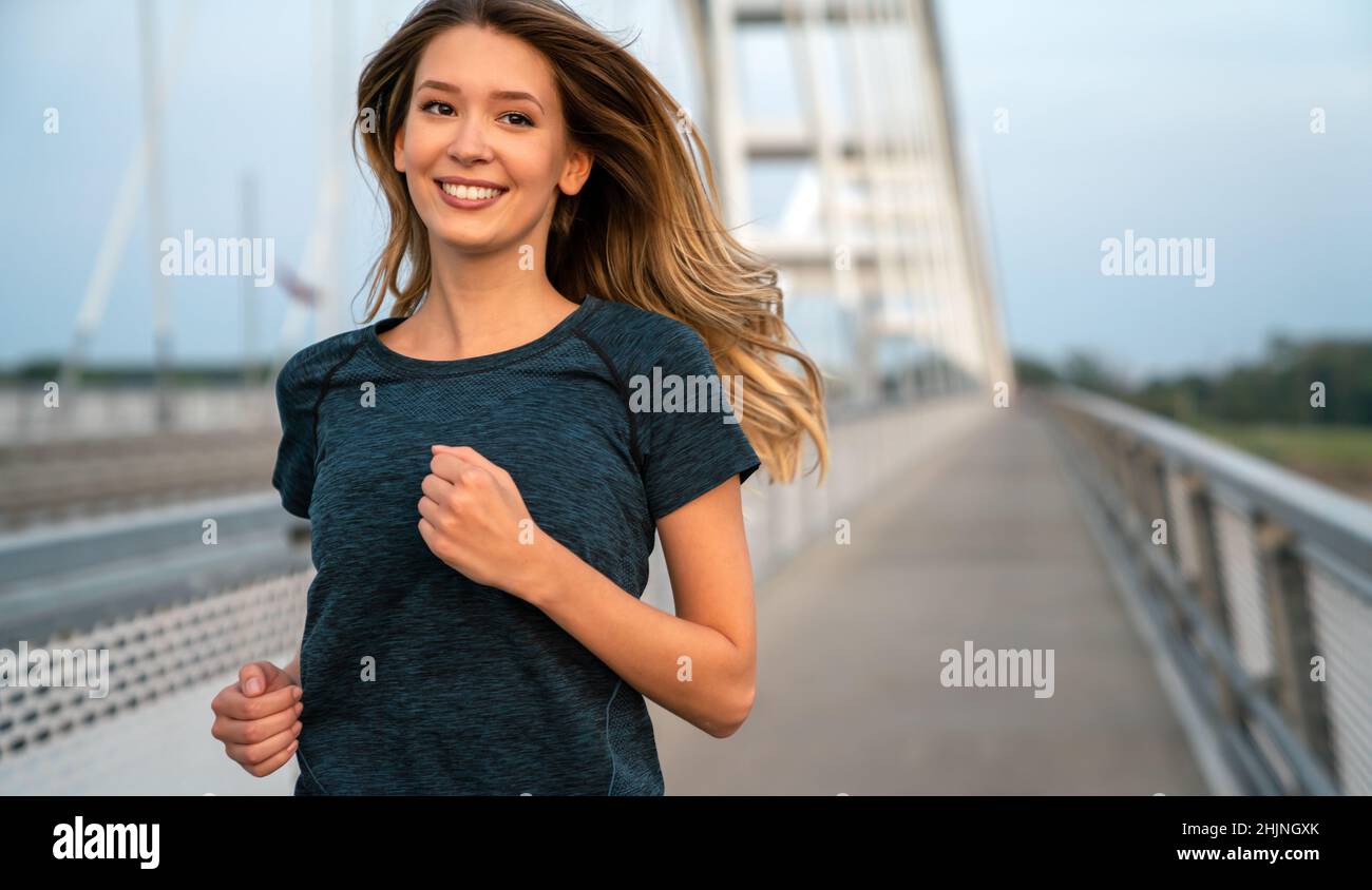 Fitness Sport Training und Lifestyle Konzept. Glücklich fit Frau läuft draußen in der Stadt. Stockfoto