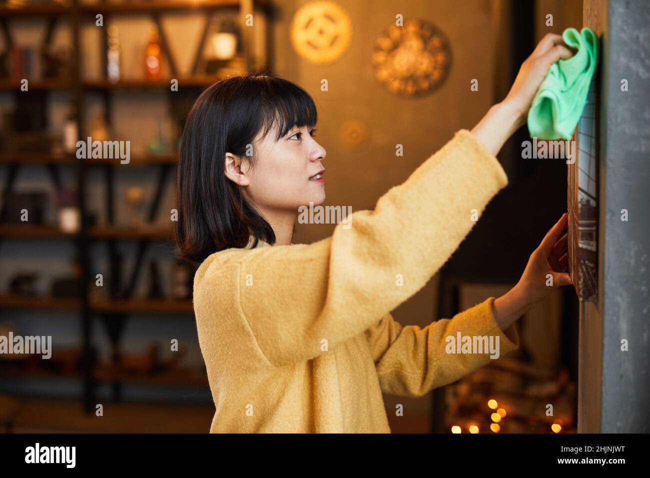 Seitenansicht Porträt der jungen asiatischen Frau Reinigung Wohnung, kopieren Raum Stockfoto