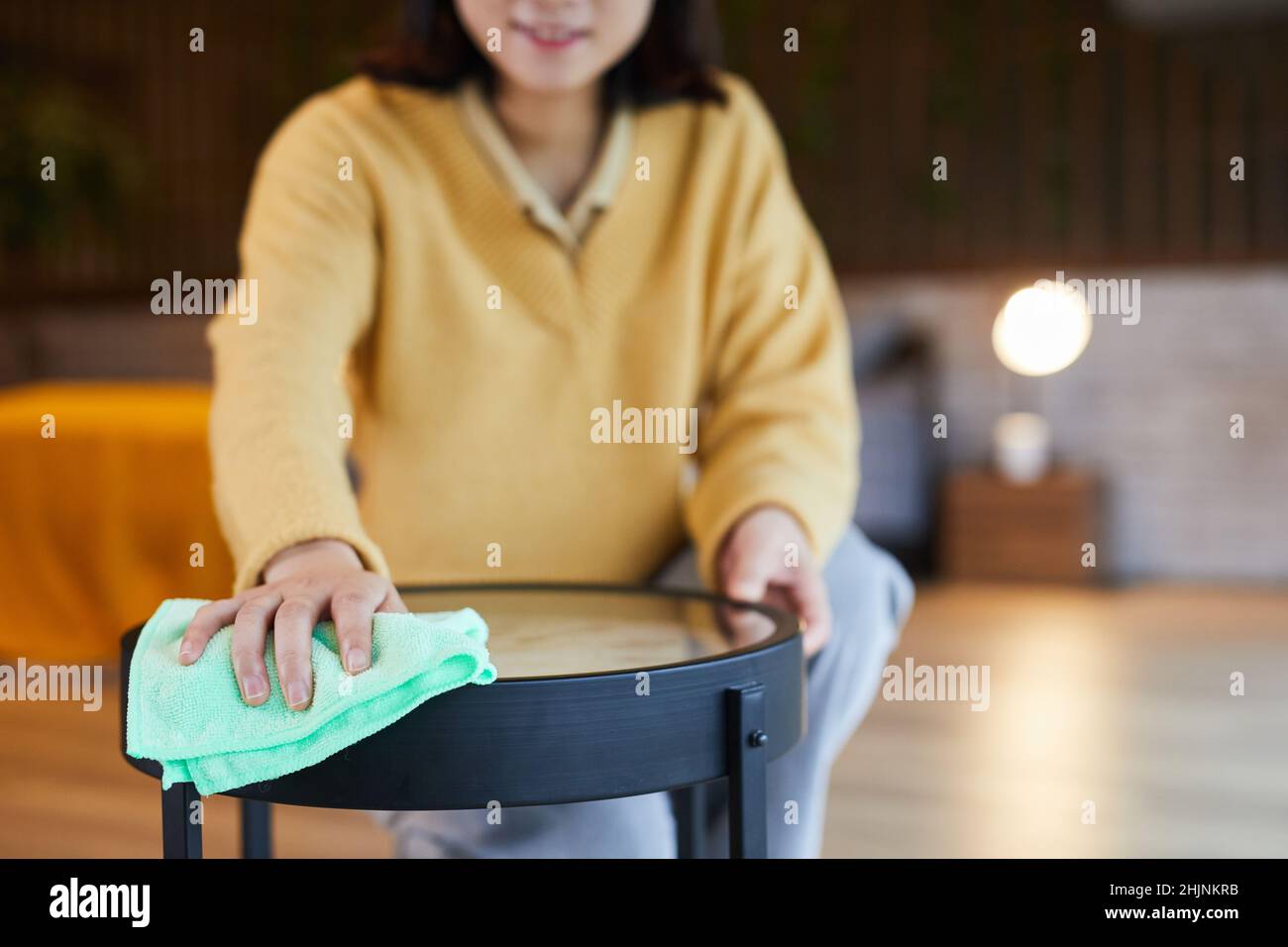 Nahaufnahme der jungen asiatischen Frau Reinigung Couchtisch in häuslicher Innenausstattung, kopieren Raum Stockfoto