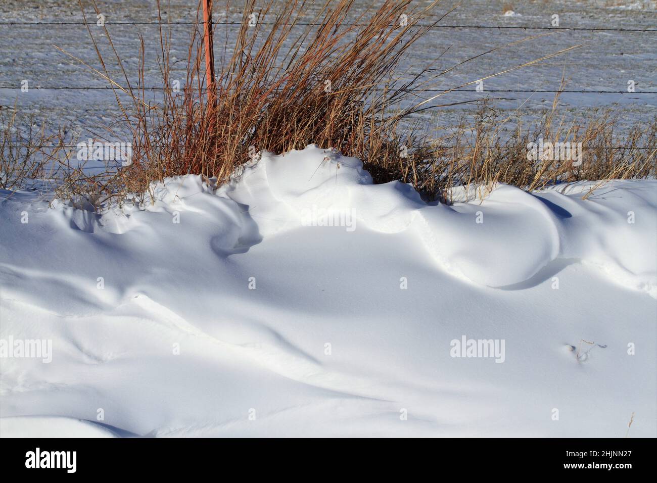 Schnee Drift mit einem Zaun und Feld auf dem Land Stockfoto
