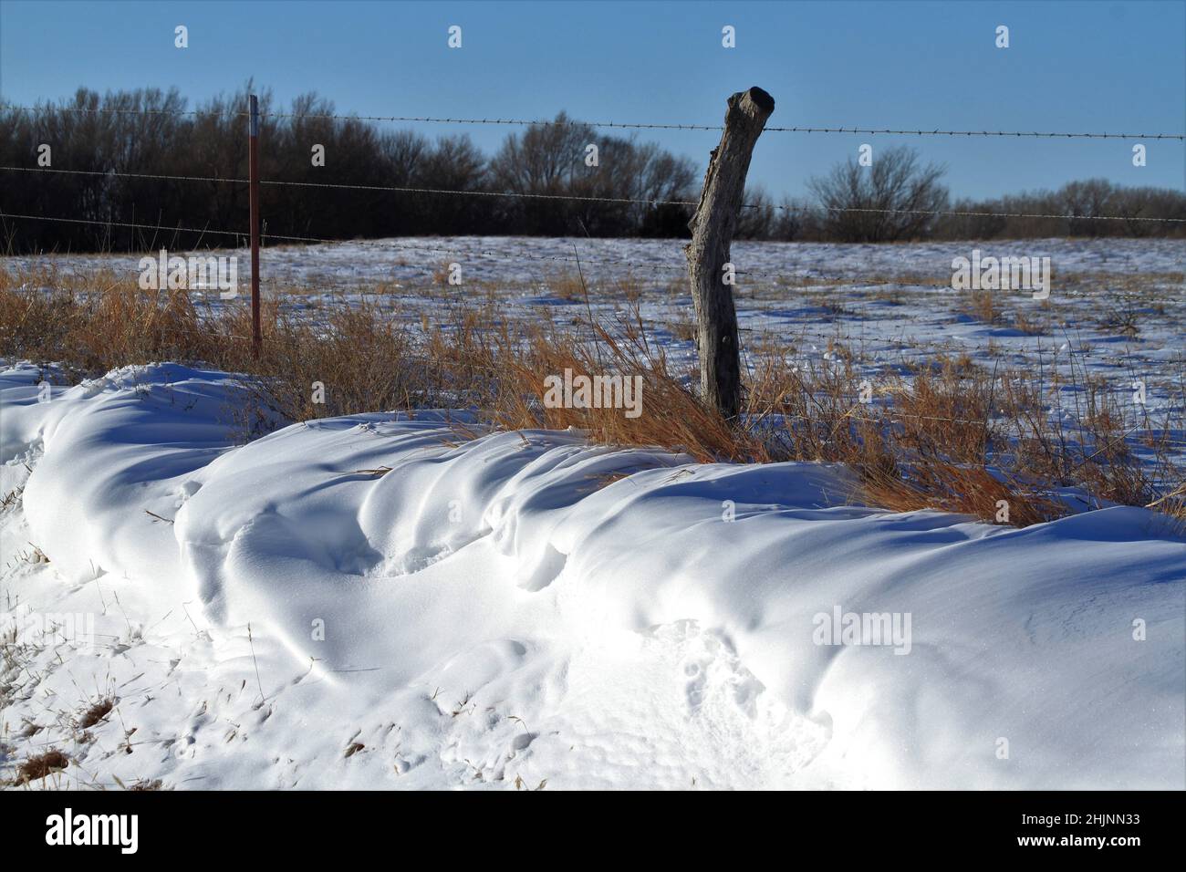 Schnee Drift mit einem Zaun und Feld auf dem Land Stockfoto