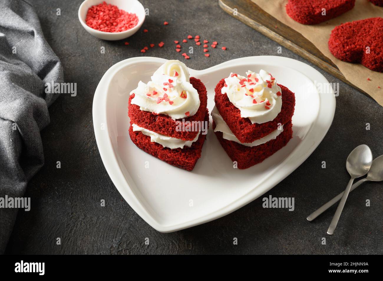 Herzförmiger roter Samtkuchen zum Valentinstag auf dunklem Hintergrund. Leckeres hausgemachtes Dessert. Stockfoto