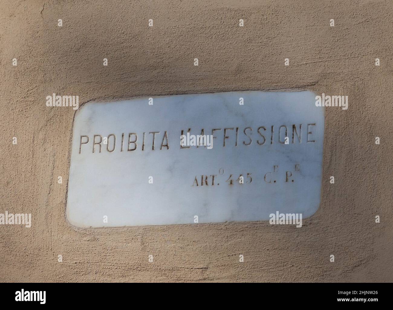 Eine Marmorplatte, die in eine Wand in Lucca, Toskana, Italien eingeführt wurde und das Verbot der Rechnungsstellung erklärt: Proibita L'Affissione. Stockfoto