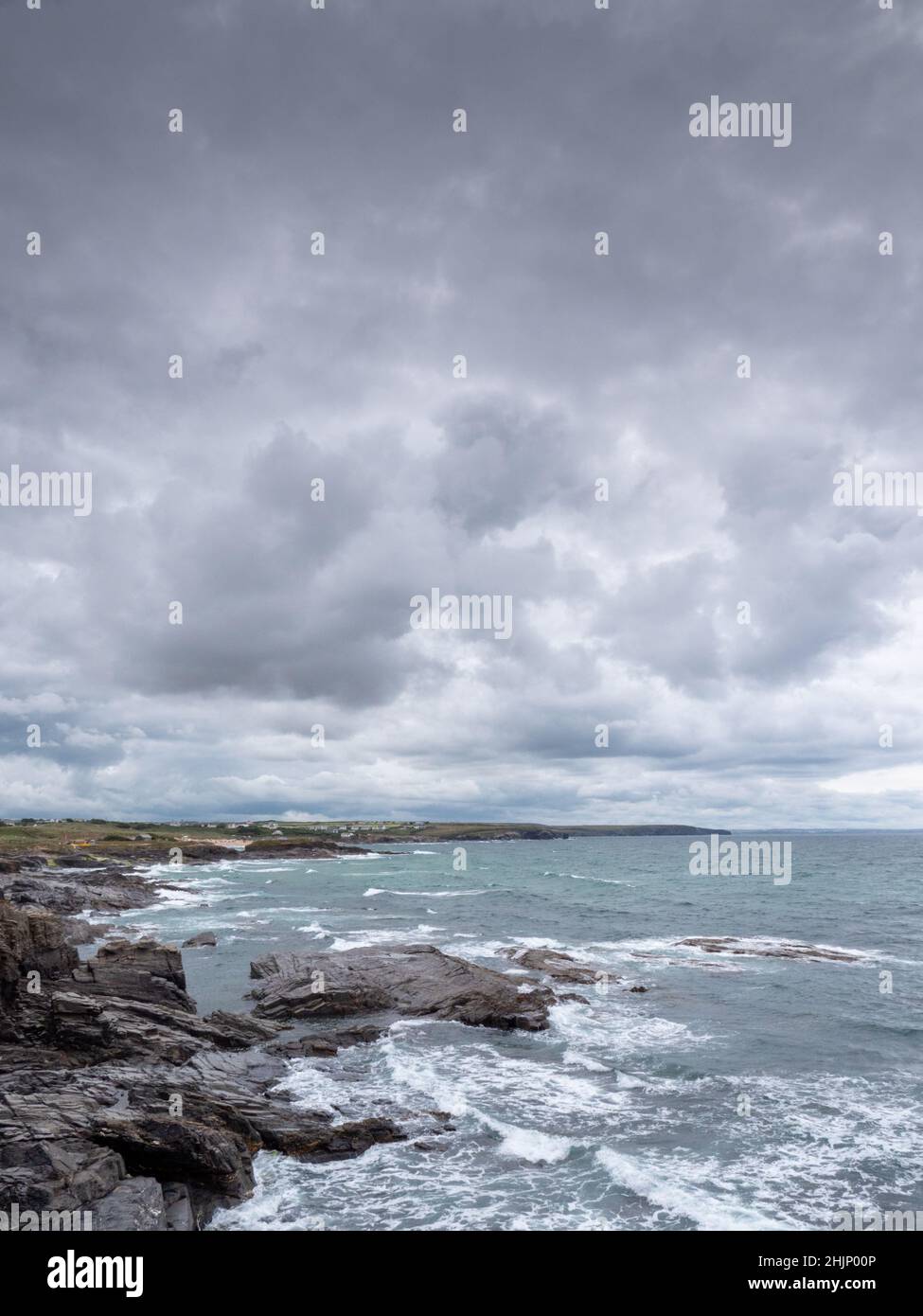 Ein Blick auf den Atlantik an der felsigen Küste von North Cornwall in der Nähe von Treyarnon Bay, der das Meer, die Wellen und einen grauen, klirrenden Himmel im Sommer in Großbritannien zeigt Stockfoto