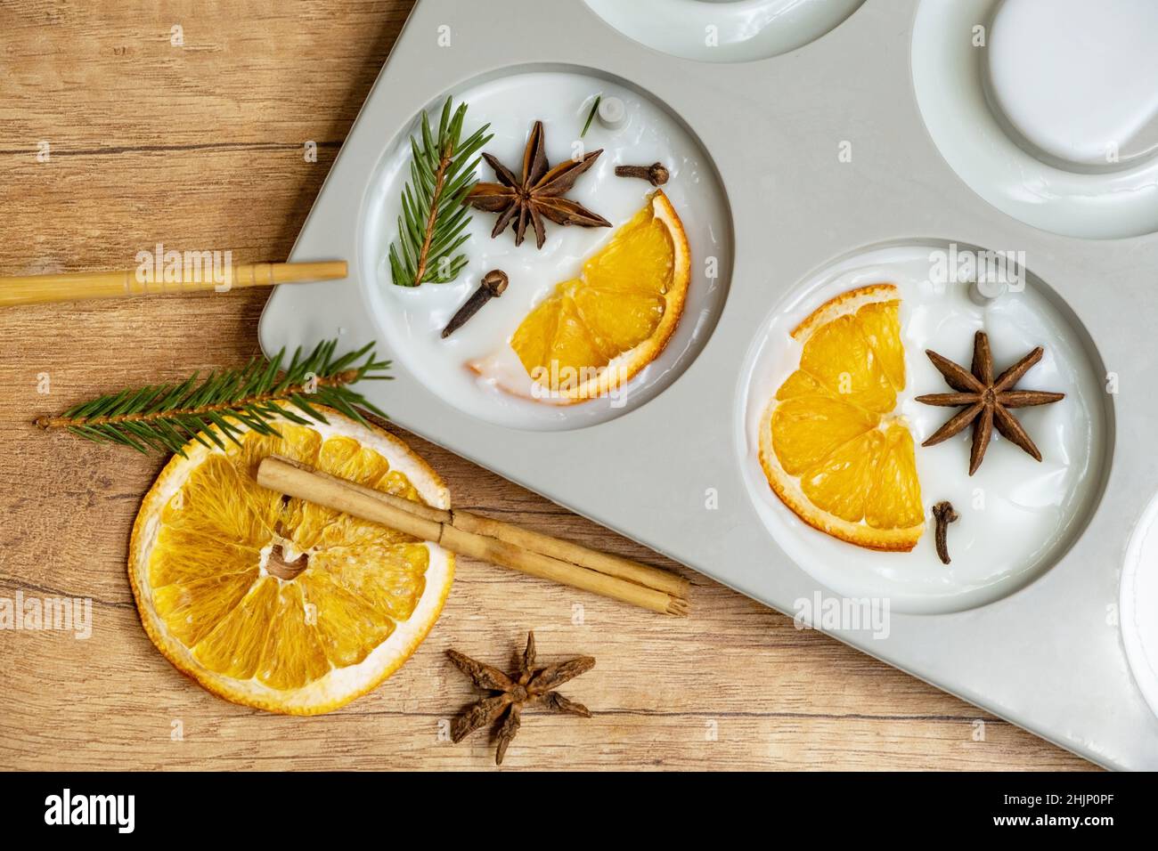 DIY Duftbeutel aus Sojawachs mit Orangenscheiben, Gewürznelken, Fichten und ätherischen Ölen aus Orange. Winterbeutel mit frischem Wachs Stockfoto