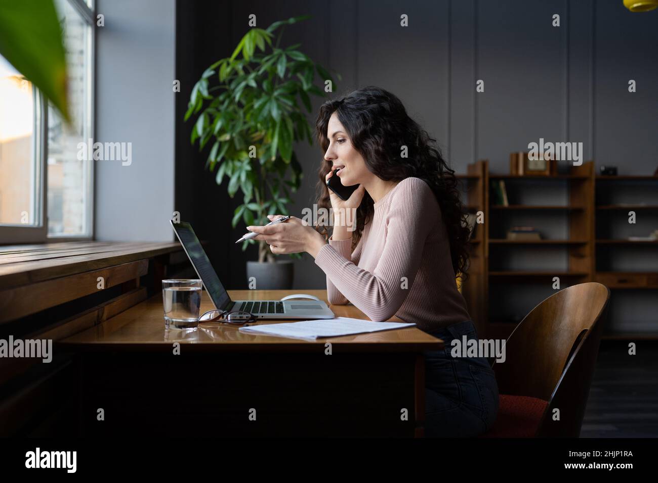 Erfolgreiche Finanzberaterin Frau Blick auf Laptop-Bildschirm besprechen Projekt auf Handy mit Kunden Stockfoto