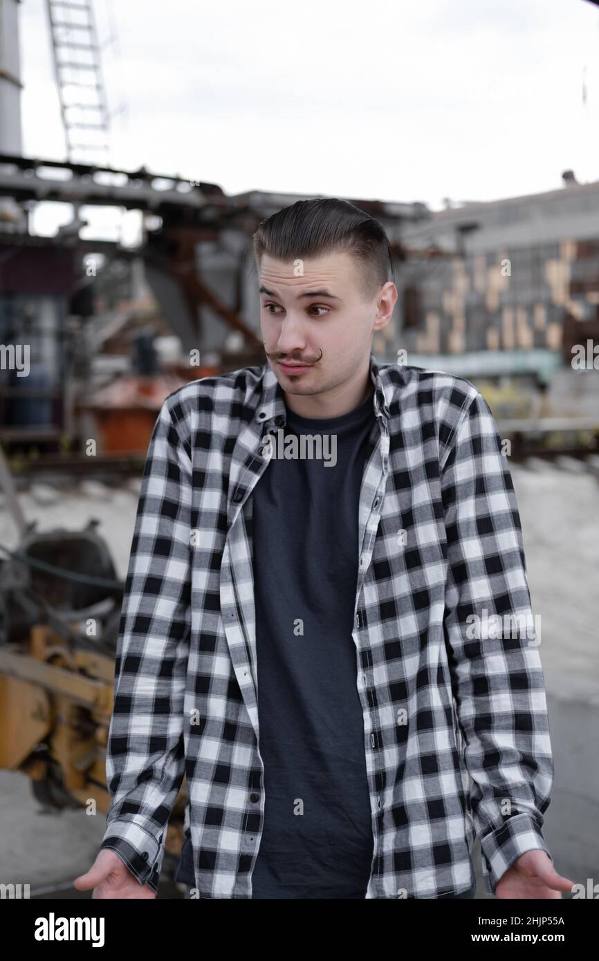 Porträt eines Mannes mit Schnurrbart im karierten schwarz-weißen Hemd außen. Stockfoto