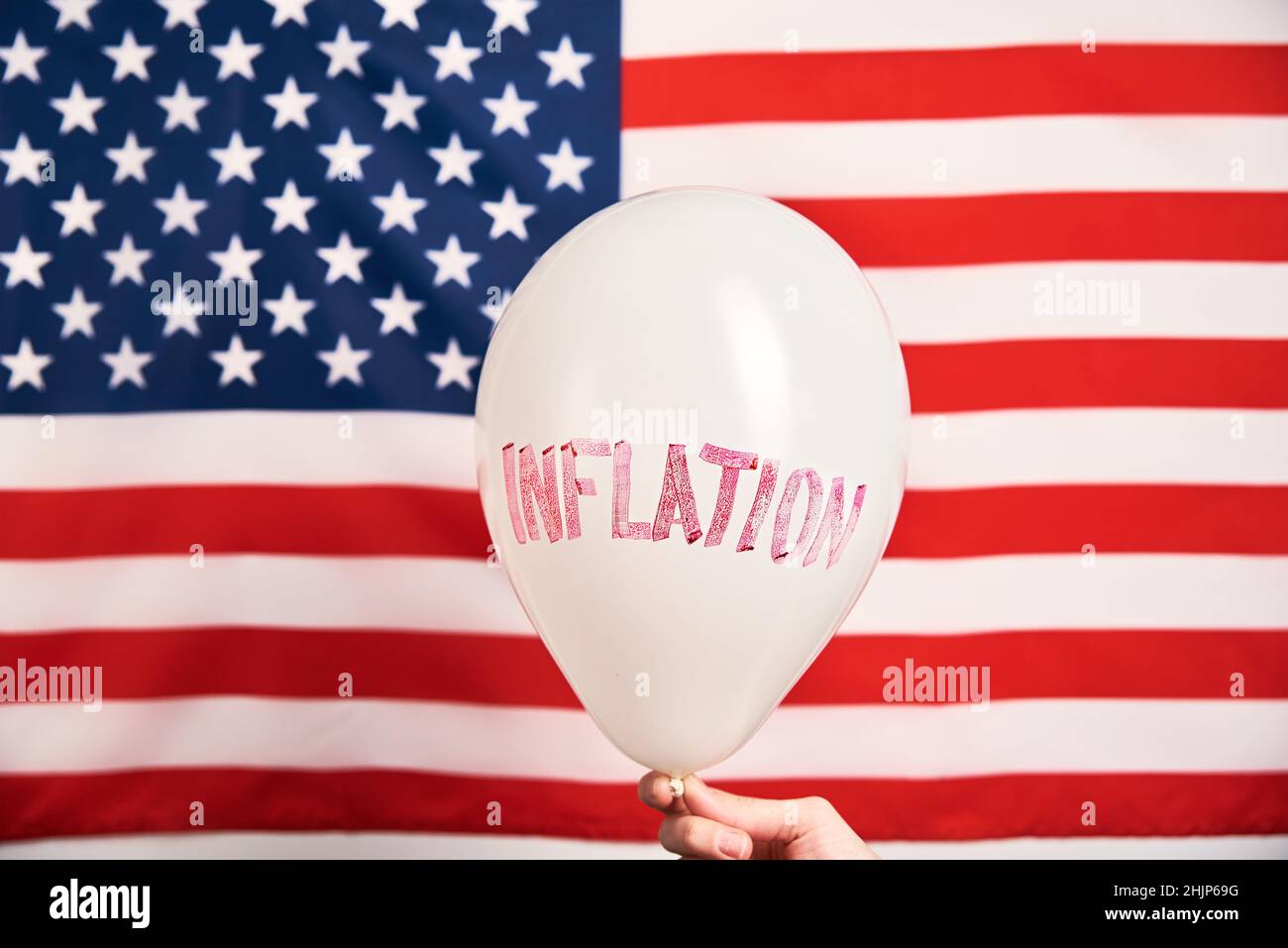 Wirtschaftskrise und Inflationskonzept, Ballon mit Wortinflation gegen us-Flagge, steigende Preise für Konsumgüter und Dienstleistungen Stockfoto
