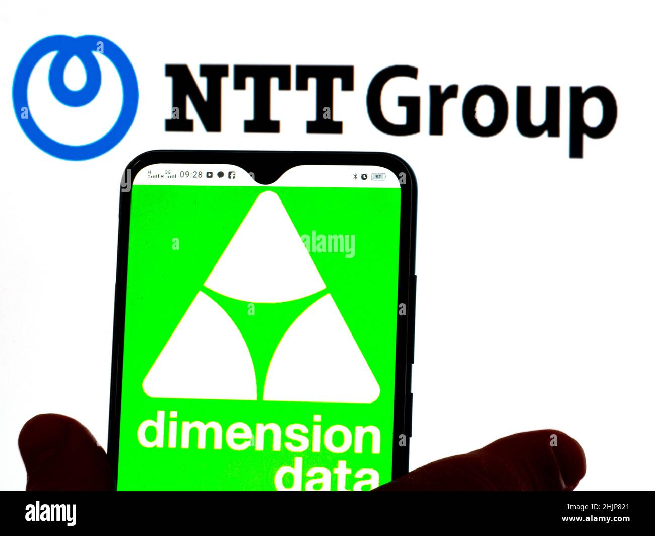 In dieser Abbildung wird das Dimension Data-Logo auf einem Smartphone-Bildschirm mit dem Logo von Nippon Telegraph und Telephone Corporation im Hintergrund angezeigt. Stockfoto