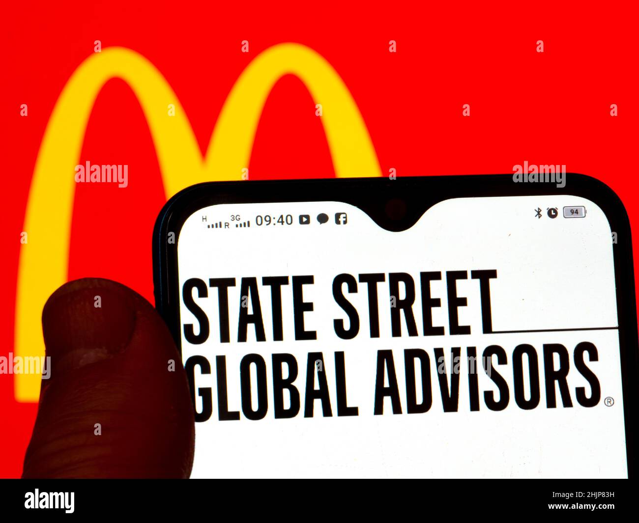 In dieser Abbildung wird das State Street Global Advisors-Logo auf einem Smartphone-Bildschirm mit dem McDonald's Corporation-Logo im Hintergrund angezeigt. Stockfoto