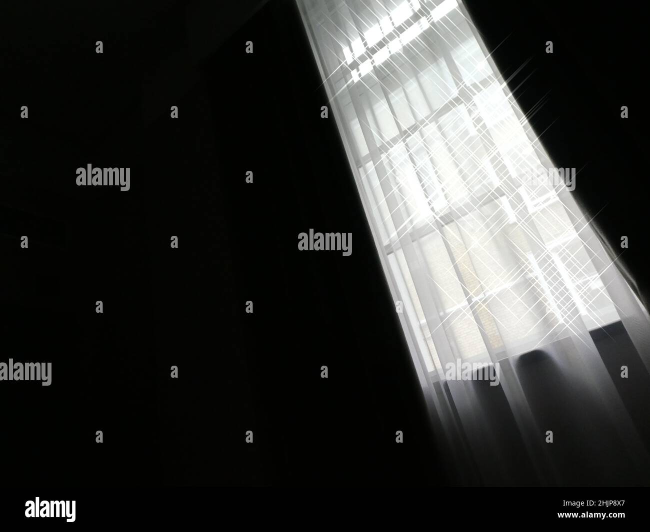 Halbabstraktes Bild eines langen, hohen Fensters mit einströmendem Sonnenlicht Stockfoto