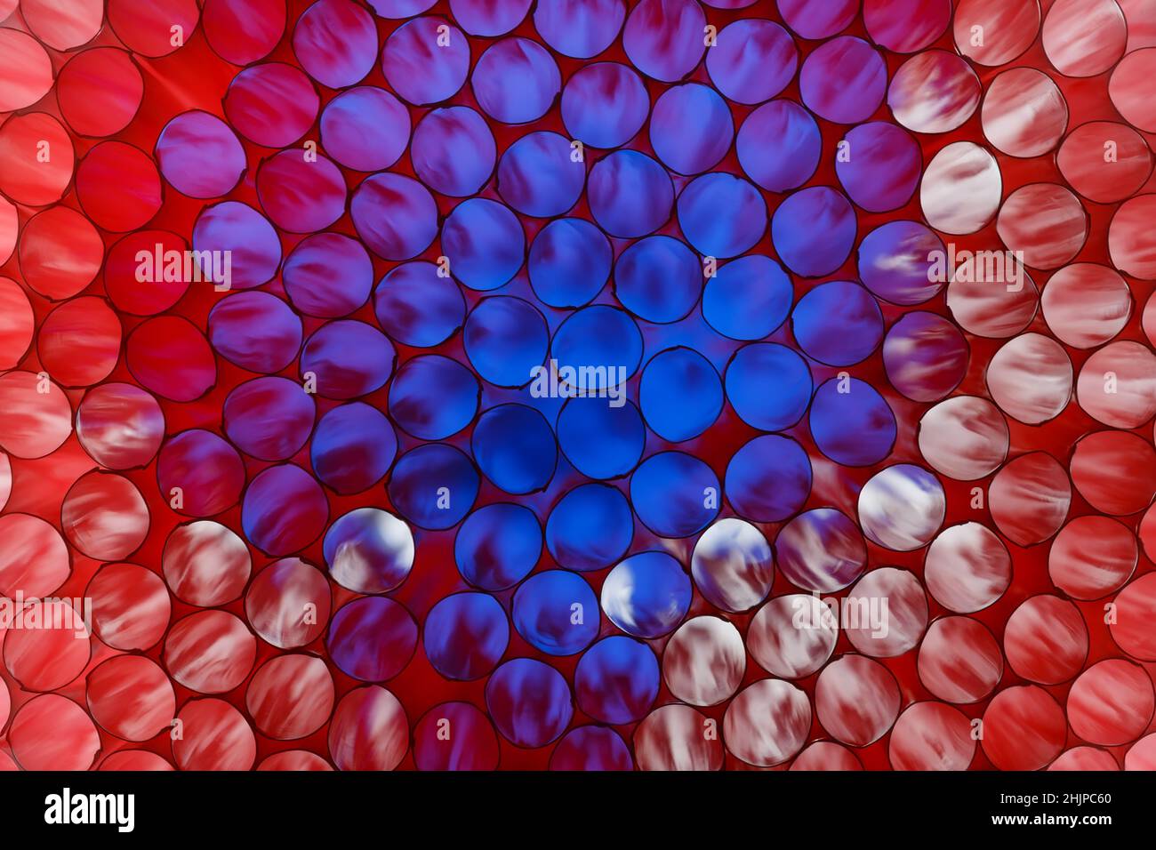 Abstrakt gefärbter Hintergrund von Trinkhalmen für einen Cocktail mit Hintergrundbeleuchtung Stockfoto