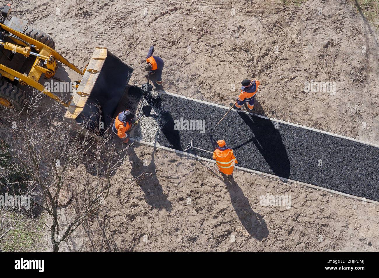 Neue Straßenbauarbeiter legen Asphalt auf Gehweg. Hot Asphalt Pflasterung Straßenarbeiter Team. Bodenarbeiten. Vorarbeit. Bodenkonstruktion Stockfoto