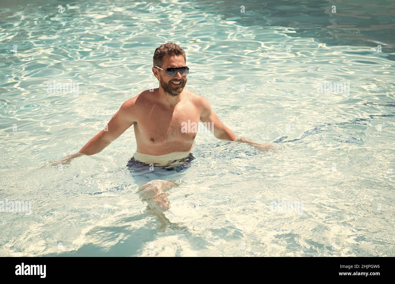 Sommer Spa Resort Urlaub. Glücklicher, gutaussehender Mann im Schwimmbad. Poolparty. Stockfoto