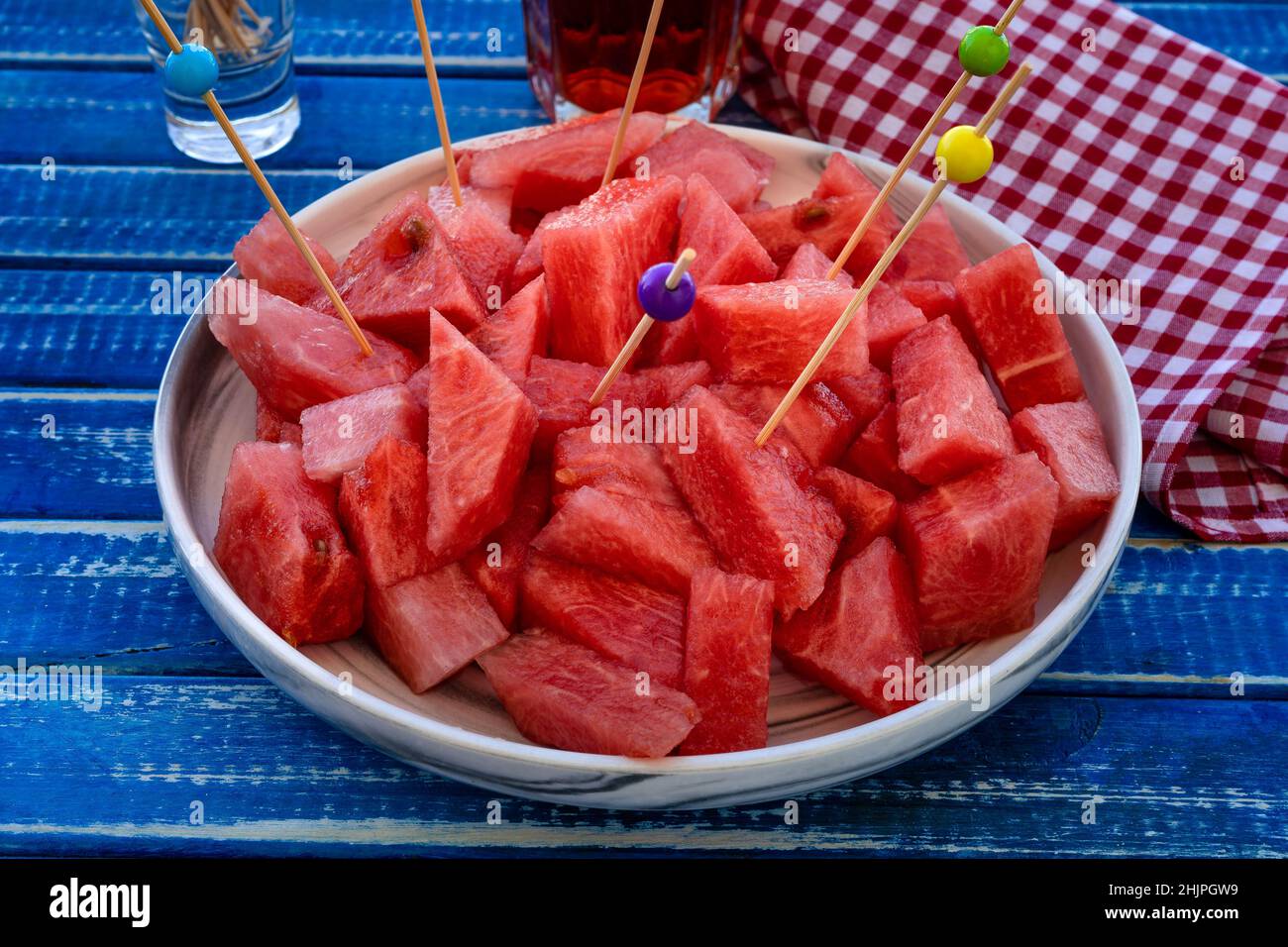 Zerklüftete kleine Stücke kalte, frische und süße Wassermelone auf einer Servierplatte mit Essstäbchen. Gesunde, frische und natürliche Lebensmittel. Früchte würzen. Stockfoto