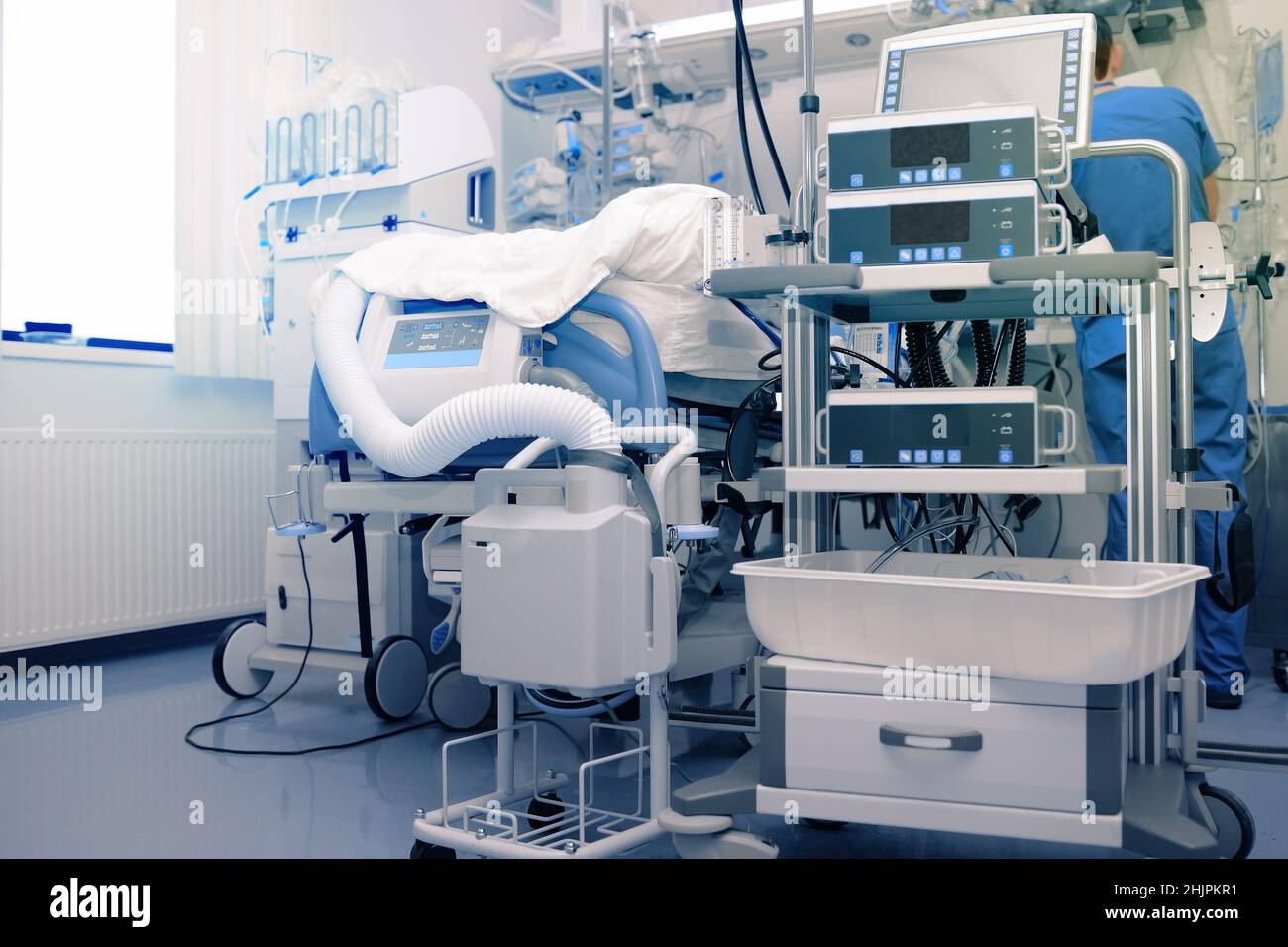 Männlicher medizinischer Mitarbeiter in der hochtechnologisch ausgerüsteten Intensivstation. Stockfoto