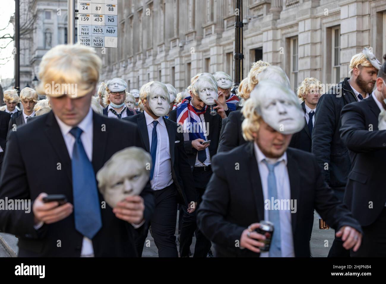 Flash-Mob von „partygate“-Anti-Boris Johnson-Demonstranten, die blonde Perücken und Gesichtsmasken von Boris Johnson tragen, vor den Toren der Downing Street, Großbritannien Stockfoto