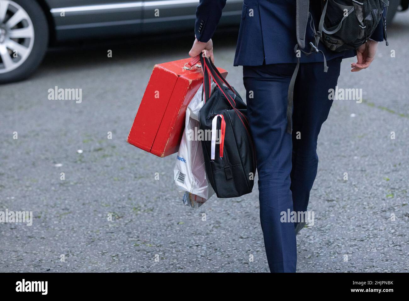 Ein junger Abgeordneter mit einem roten Koffer kommt in der Downing Street Nr. 10, London, Großbritannien, an Stockfoto