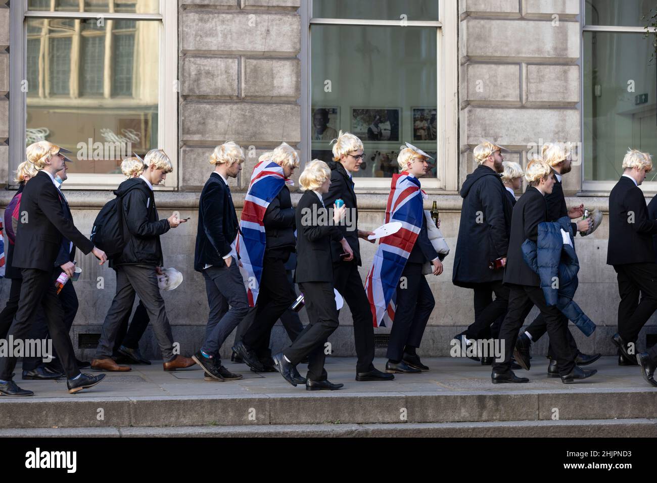 Flash-Mob von „partygate“-Anti-Boris Johnson-Demonstranten, die blonde Perücken und Gesichtsmasken von Boris Johnson tragen, vor den Toren der Downing Street, Großbritannien Stockfoto