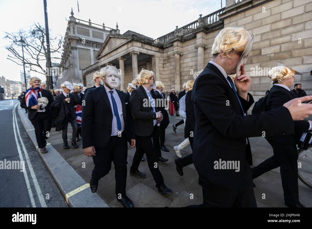Flash-Mob von „partygate“-Anti-Boris Johnson-Demonstranten, die blonde Perücken und Gesichtsmasken von Boris Johnson tragen, vor den Toren der Downing Street, Großbritannien Stockfoto