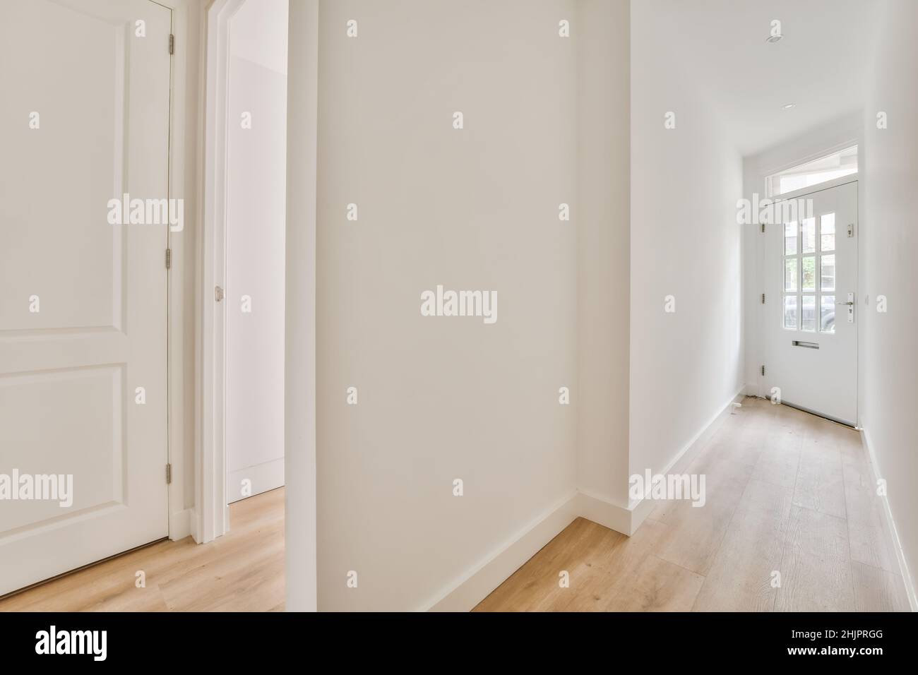 Stilvoller Korridor mit Parkettboden und Eingangstür Stockfoto