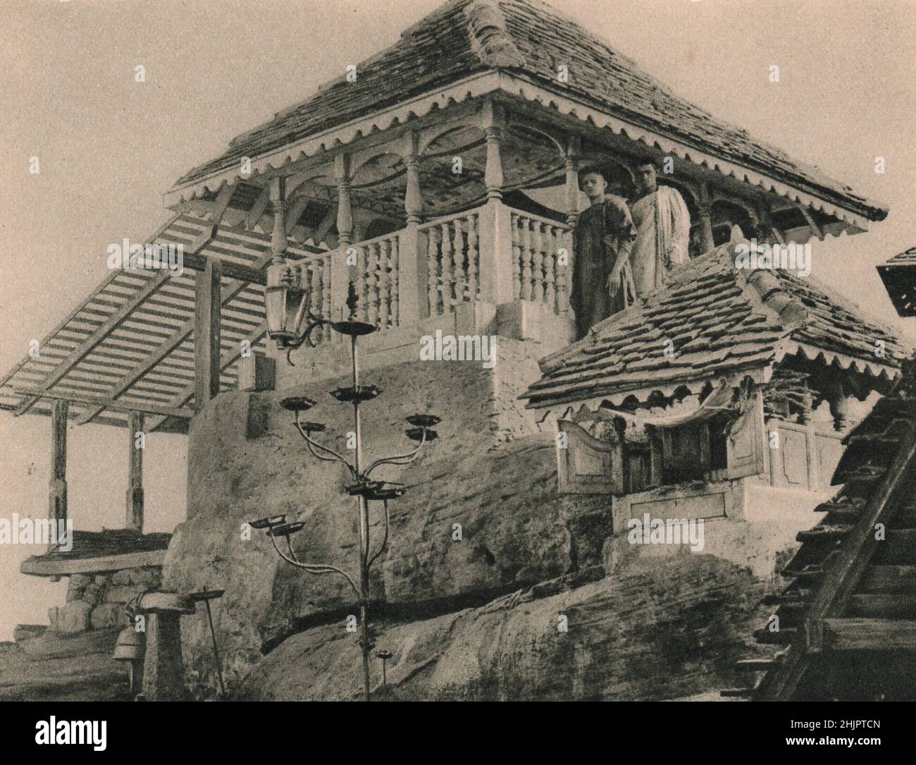 Buddhistische Mönche bewachen den hölzernen Baldachin über dem Eindruck auf dem Felsen auf Adams Gipfel, der als Fußabdruck Buddhas verehrt wird. Sri Lanka. Ceylon (1923) Stockfoto