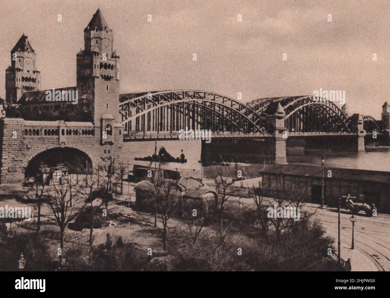 Die Hohenzollernbrücke trägt eine Doppelbahn und eine Fahrbahn. Die Statue links ist von Friedrich Wilhelm IV. Deutschland. Köln (1923) Stockfoto