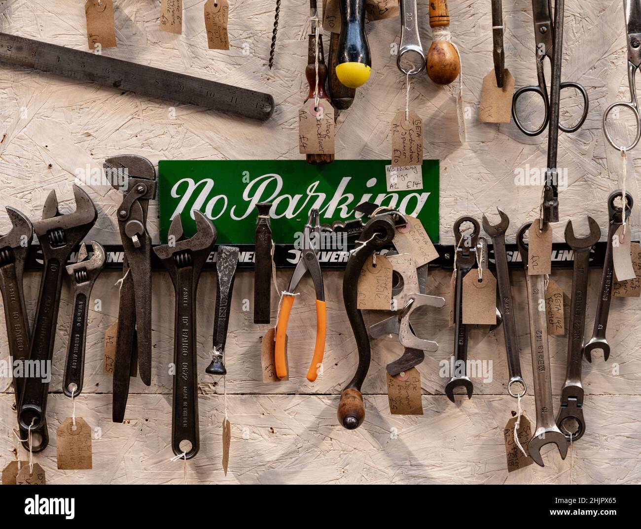 Verschiedene Vintage-Werkzeuge zum Verkauf Aufhängen in einer Garage mit No Parking-Schild in Shropshire, West Midlands Stockfoto
