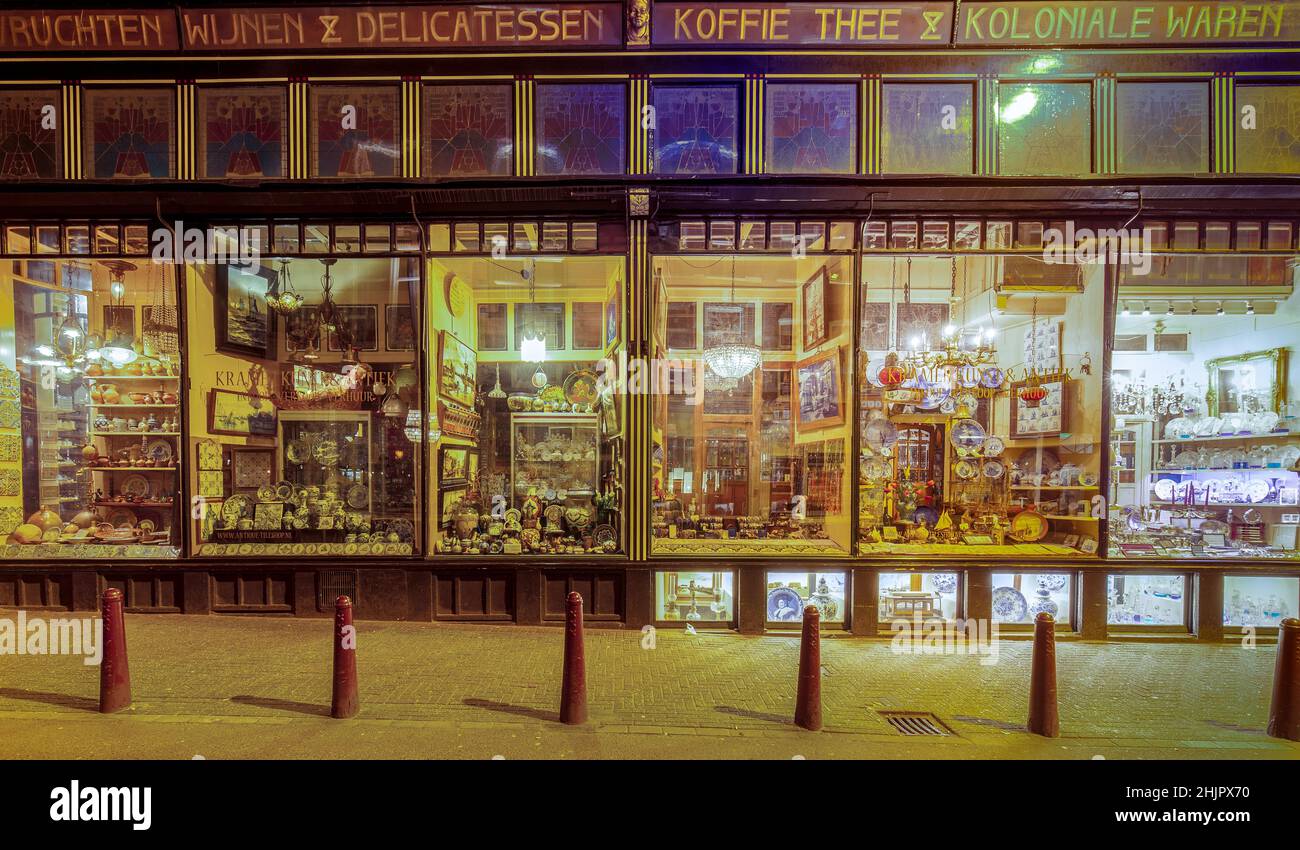 Panorama eines alten Antiquitätenladens mit mehreren Gegenständen in den Fenstern, die Amsterdam Holland ausgestellt hat Stockfoto