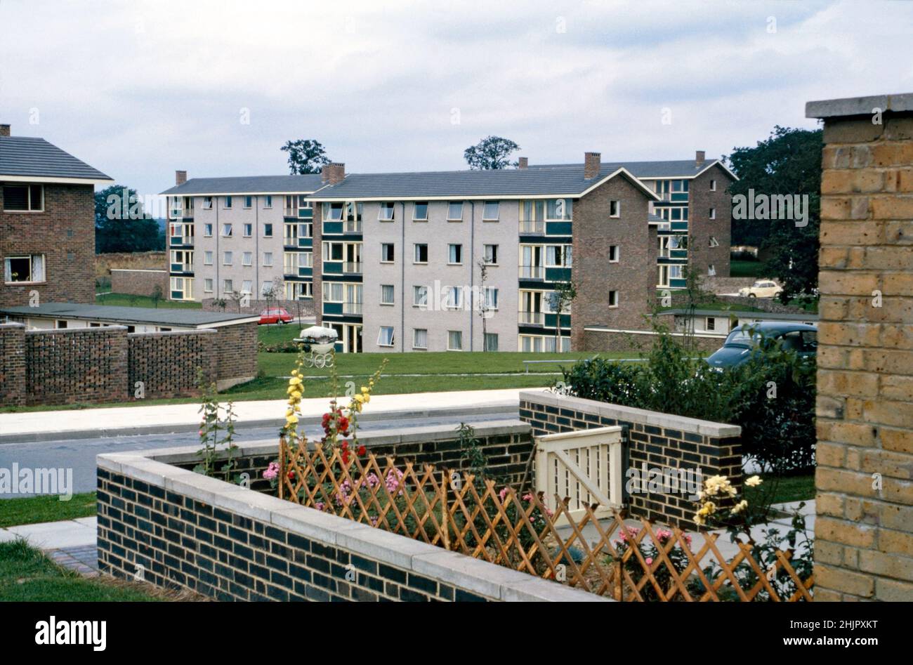 Vier-stöckige Wohnblocks in Avon Walk, in der Gossops Green Area von Crawley ‘New Town’, West Sussex, England, Großbritannien, im Jahr 1962. Auf dem Gemeinschaftsgrün wurde ein Kinderwagen an der frischen Luft gelassen – vielleicht etwas, das heute nicht passieren würde. Das Viertel, westlich des Stadtzentrums, war eines von 14 Vororten, die zur Schaffung der ‘neuen Stadt’ nach dem Krieg entwickelt wurden. Nach dem Zweiten Weltkrieg wurden viele Menschen und Arbeitsplätze in die neuen Städte im Südosten Englands verlegt, um diejenigen in Londons armen oder bombardierten Wohnungen zu verlagern, und Crawley war das einzige von ihnen – ein altes Foto aus dem Jahr 1960s. Stockfoto